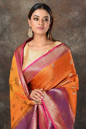 Buy beautiful orange Banarasi sari online in USA with pink purple zari border. Look royal at weddings and festive occasions in exquisite Banarasi sarees, handwoven sarees, tussar silk sarees, Bollywood sarees, partywear sarees from Pure Elegance Indian saree store in USA.-closeup
