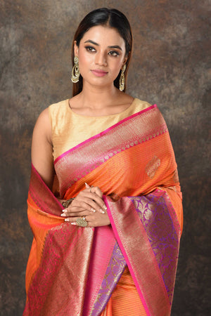 Shop orange Banarasi sari online in USA with purple pink zari border. Look royal at weddings and festive occasions in exquisite Banarasi saris, handwoven sarees, tussar silk sarees, Bollywood sarees, partywear sarees from Pure Elegance Indian saree store in USA.-closeup