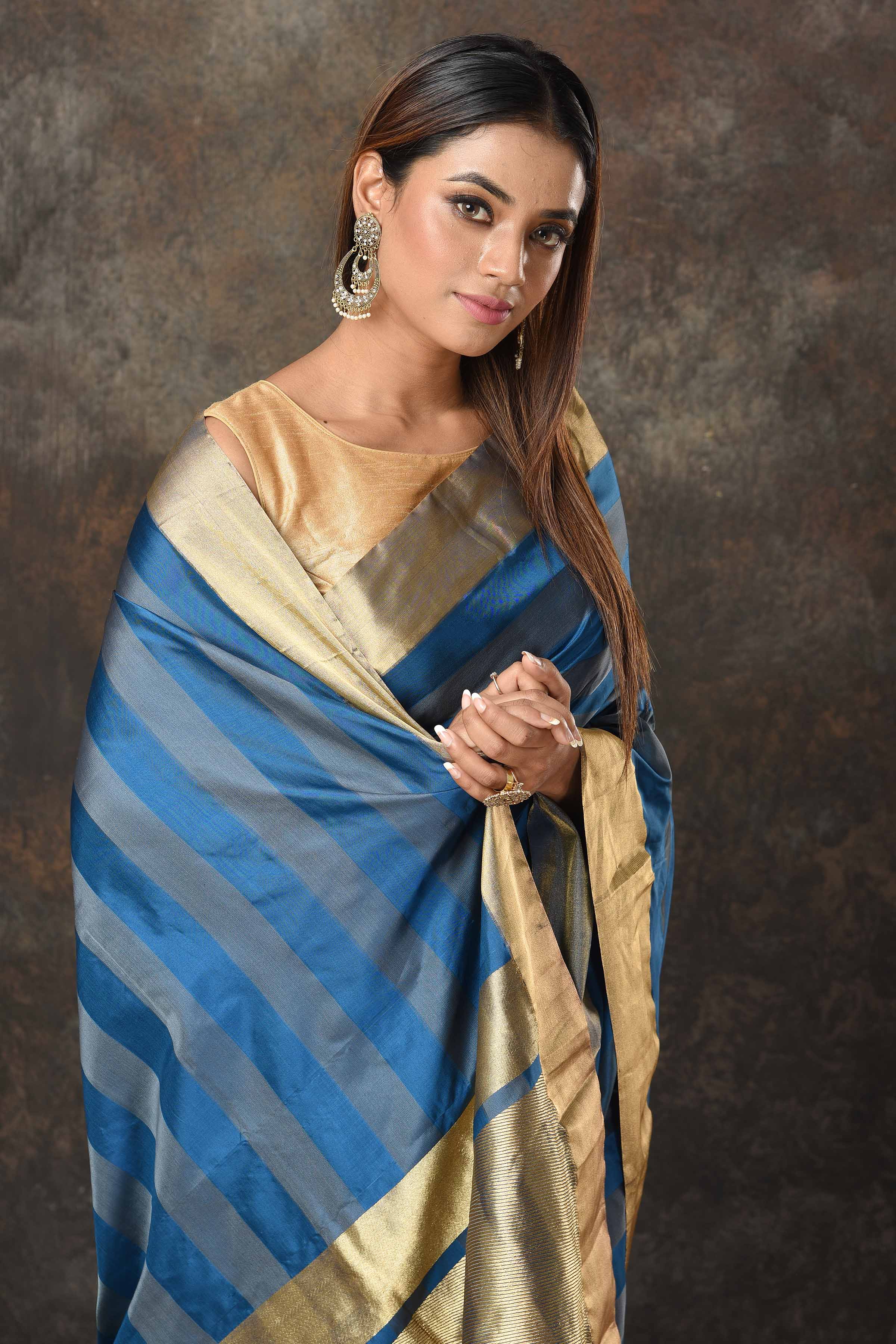 Shop stunning blue grey stripes Banarasi Mashru silk saree online in USA with golden border. Radiate elegance on special occasions in exquisite designer sarees, handwoven sarees, georgette sarees, embroidered sarees, Banarasi saree, pure silk saris, tussar sarees from Pure Elegance Indian saree store in USA.-closeup