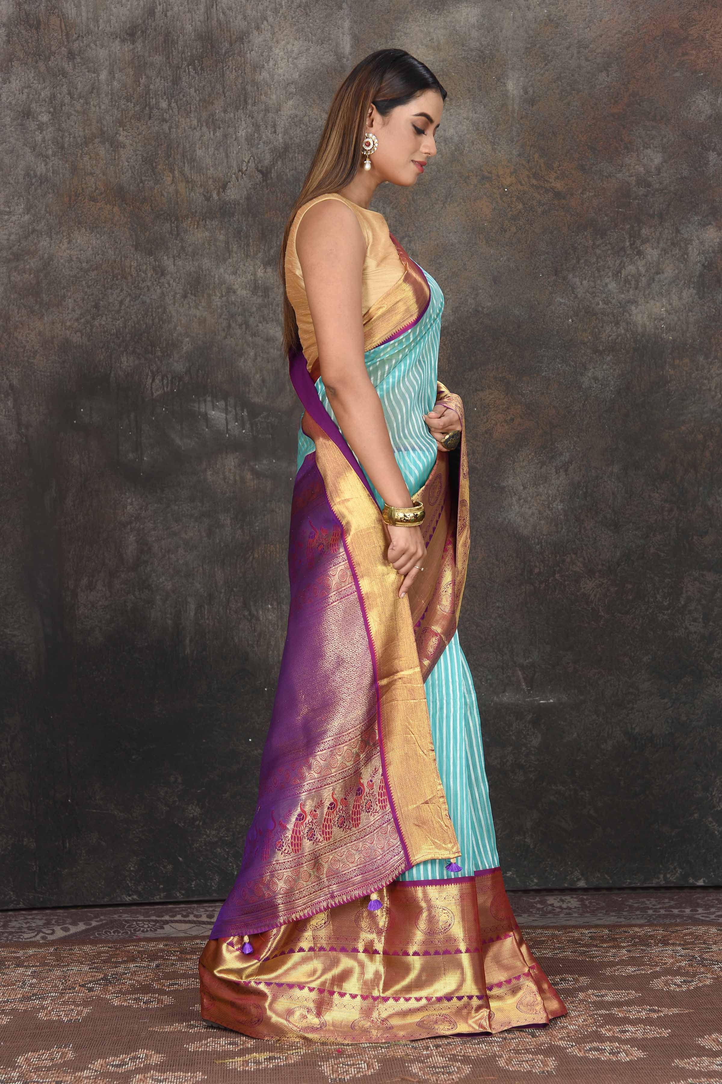 Buy beautiful light blue Banarasi stripes Kanjeevaram saree online in USA with golden zari border. Be the center of attraction on special occasions in ethnic sarees, designer sarees, embroidered sarees, handwoven sarees, pure silk sarees from Pure Elegance Indian saree store in USA.-side