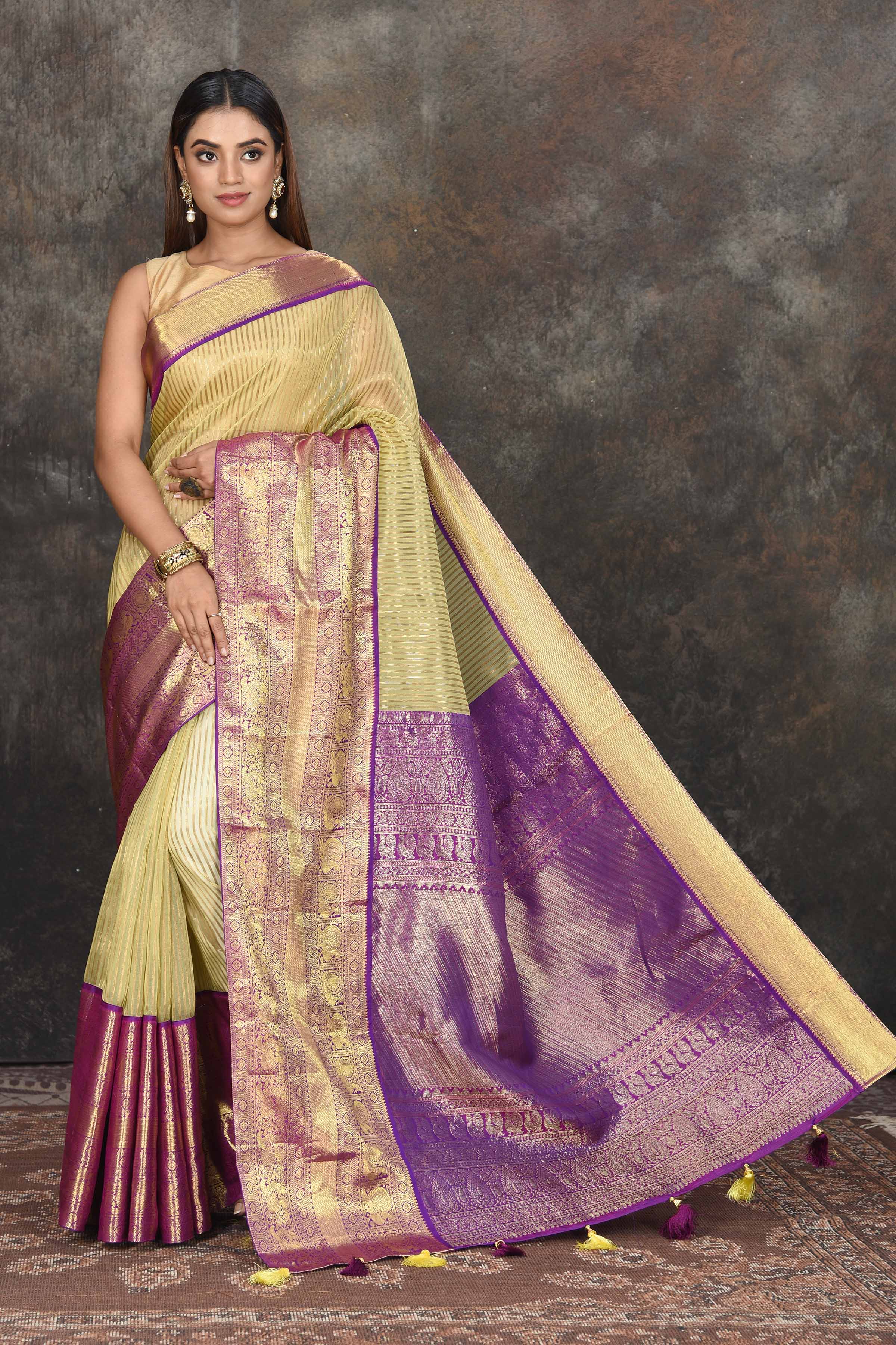 Buy beautiful yellow Kanjeevaram Kora striped saree online in USA with purple zari border. Be the center of attraction on special occasions in ethnic sarees, designer sarees, embroidered sarees, handwoven sarees, pure silk sarees from Pure Elegance Indian saree store in USA.-full view