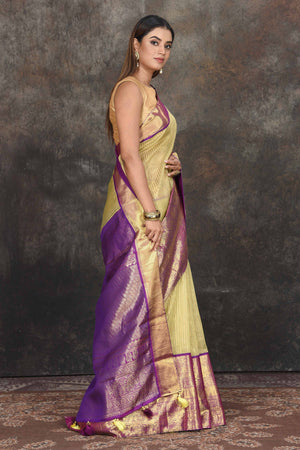 Buy beautiful yellow Kanjeevaram Kora striped saree online in USA with purple zari border. Be the center of attraction on special occasions in ethnic sarees, designer sarees, embroidered sarees, handwoven sarees, pure silk sarees from Pure Elegance Indian saree store in USA.-side