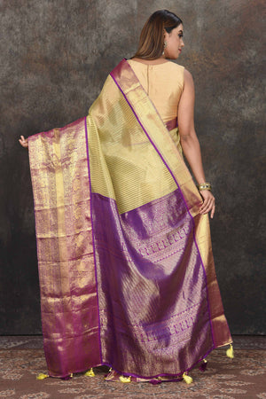 Buy beautiful yellow Kanjeevaram Kora striped saree online in USA with purple zari border. Be the center of attraction on special occasions in ethnic sarees, designer sarees, embroidered sarees, handwoven sarees, pure silk sarees from Pure Elegance Indian saree store in USA.-back