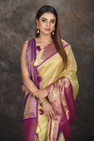 Buy beautiful yellow Kanjeevaram Kora striped saree online in USA with purple zari border. Be the center of attraction on special occasions in ethnic sarees, designer sarees, embroidered sarees, handwoven sarees, pure silk sarees from Pure Elegance Indian saree store in USA.-closeup