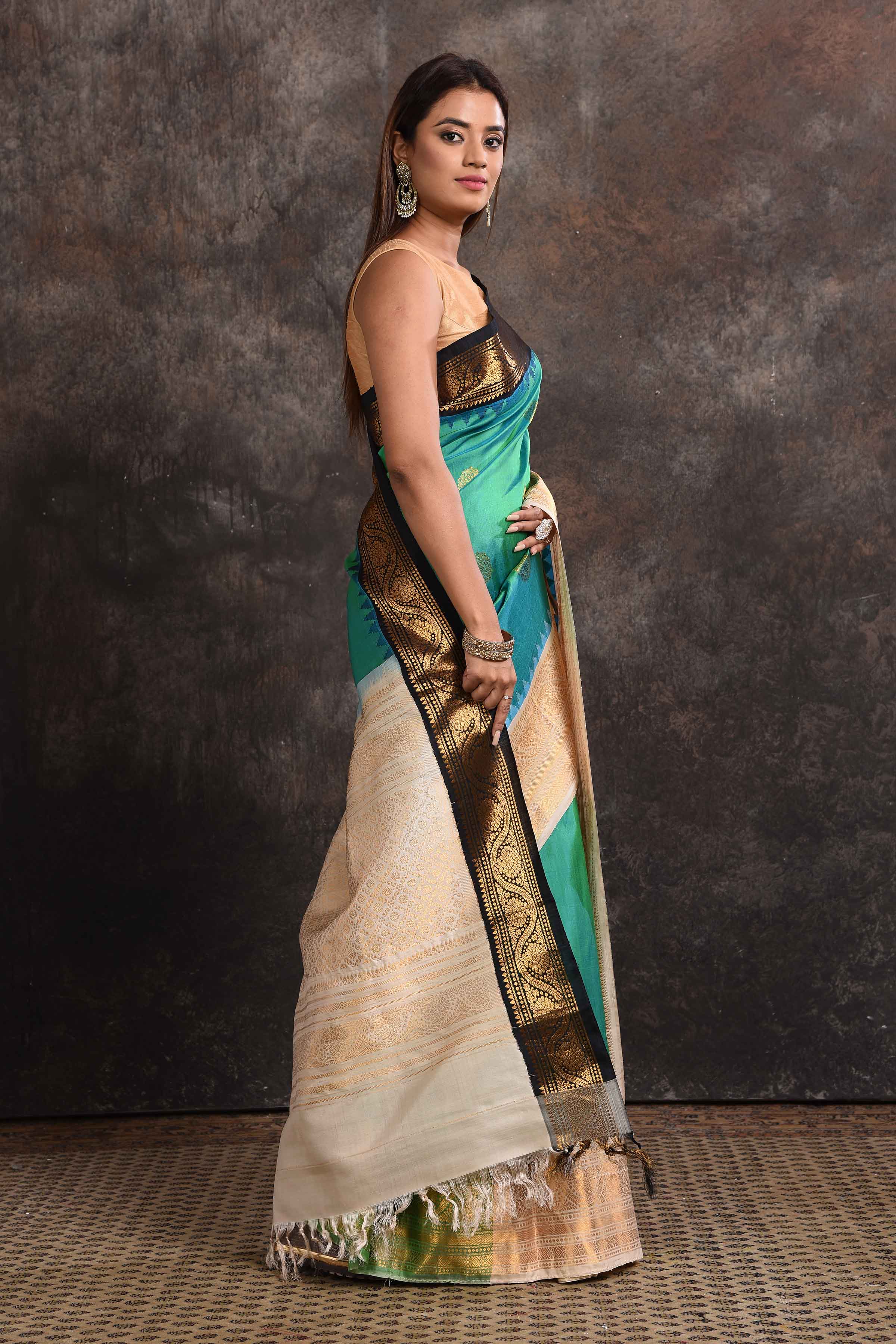 Buy stunning sea green Gadhwal silk sari online in USA with black and cream zari border. Look your ethnic best on festive occasions with latest designer sarees, pure silk sarees, Kanchipuram silk sarees, handwoven sarees, tussar silk sarees, embroidered sarees from Pure Elegance Indian saree store in USA.-side