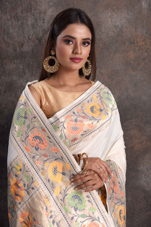 Shop cream muga silk saree online in USA with floral border, Be a vision of ethnic elegance on festive occasions in beautiful designer sarees, silk sarees, handloom sarees, Kanchipuram silk sarees, embroidered sarees from Pure Elegance Indian saree store in USA. -closeup
