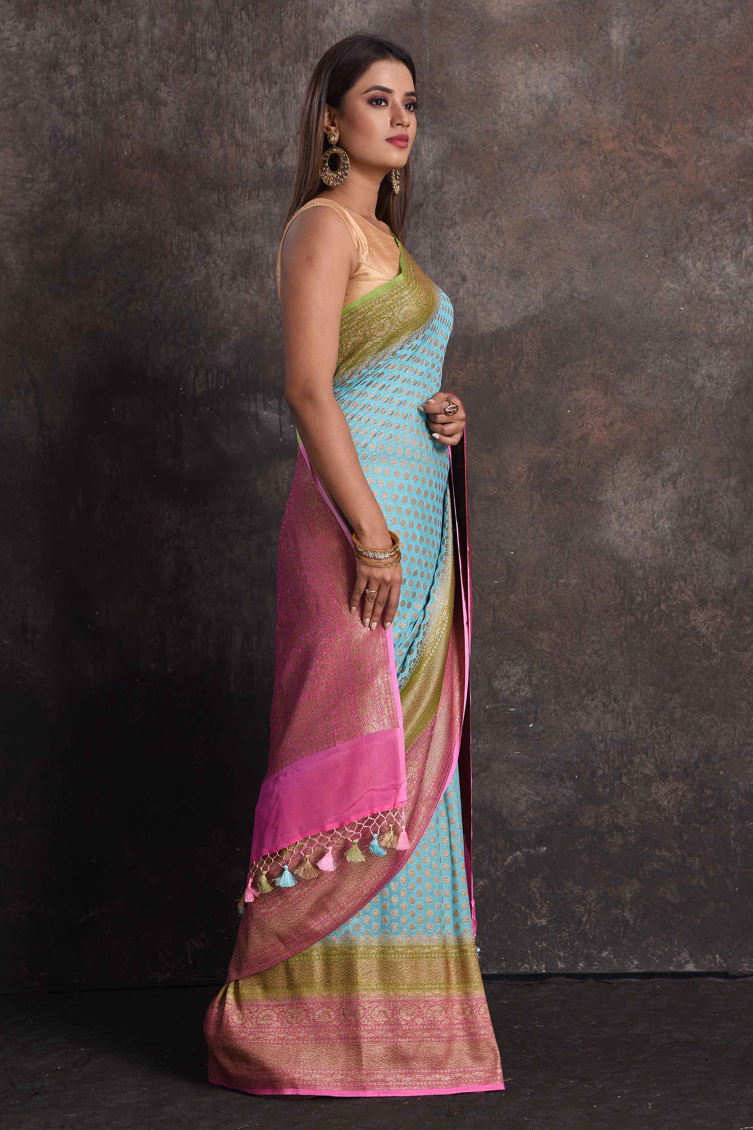Buy beautiful sky blue georgette Banarasi saree online in USA with pink and green border, Be a vision of ethnic elegance on festive occasions in beautiful designer sarees, silk sarees, handloom sarees, Kanchipuram silk sarees, embroidered sarees from Pure Elegance Indian saree store in USA. -right