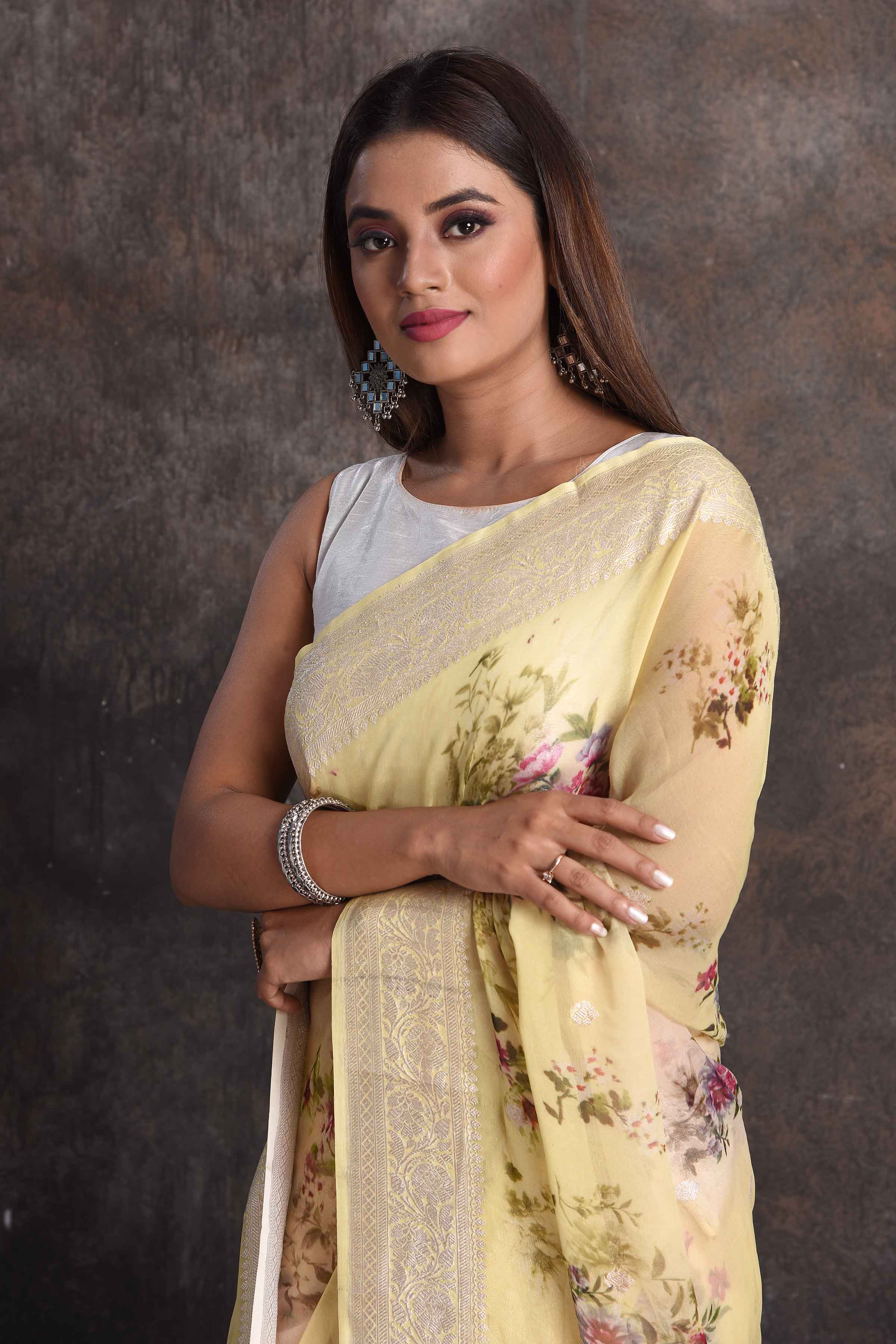 Buy beautiful light yellow floral georgette saree online in USA with zari border, Be a vision of ethnic elegance on festive occasions in beautiful designer sarees, silk sarees, handloom sarees, Kanchipuram silk sarees, embroidered sarees from Pure Elegance Indian saree store in USA. -closeup