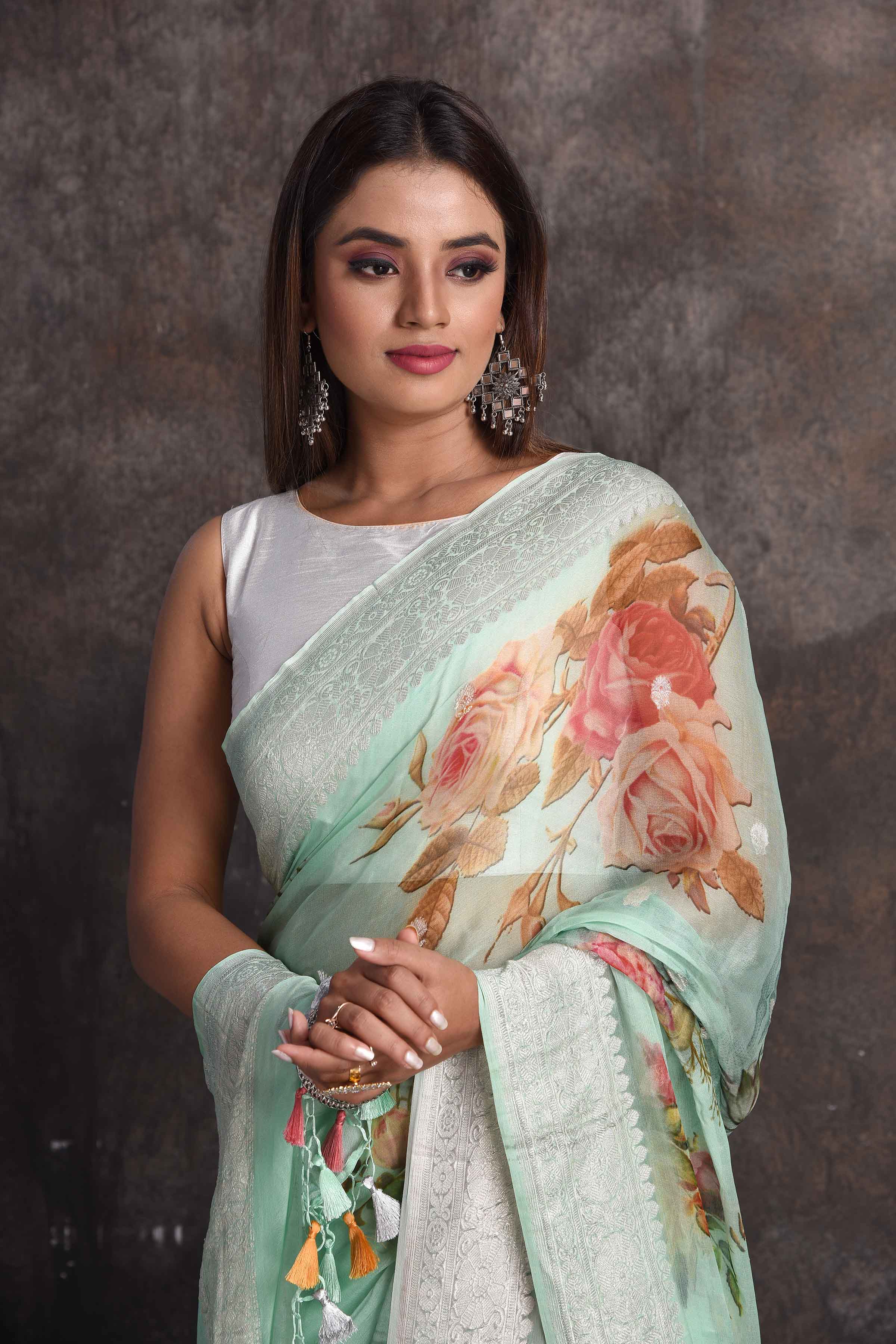 Shop beautiful pastel green floral georgette saree online in USA with zari border, Be a vision of ethnic elegance on festive occasions in beautiful designer sarees, silk sarees, handloom sarees, Kanchipuram silk sarees, embroidered sarees from Pure Elegance Indian saree store in USA. -closeup
