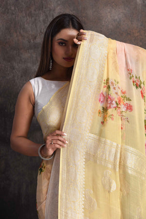Shop gorgeous peachish yellow floral print georgette saree online in USA with zari border, Be a vision of ethnic elegance on festive occasions in beautiful designer sarees, silk sarees, handloom sarees, Kanchipuram silk sarees, embroidered sarees from Pure Elegance Indian saree store in USA. -closeup