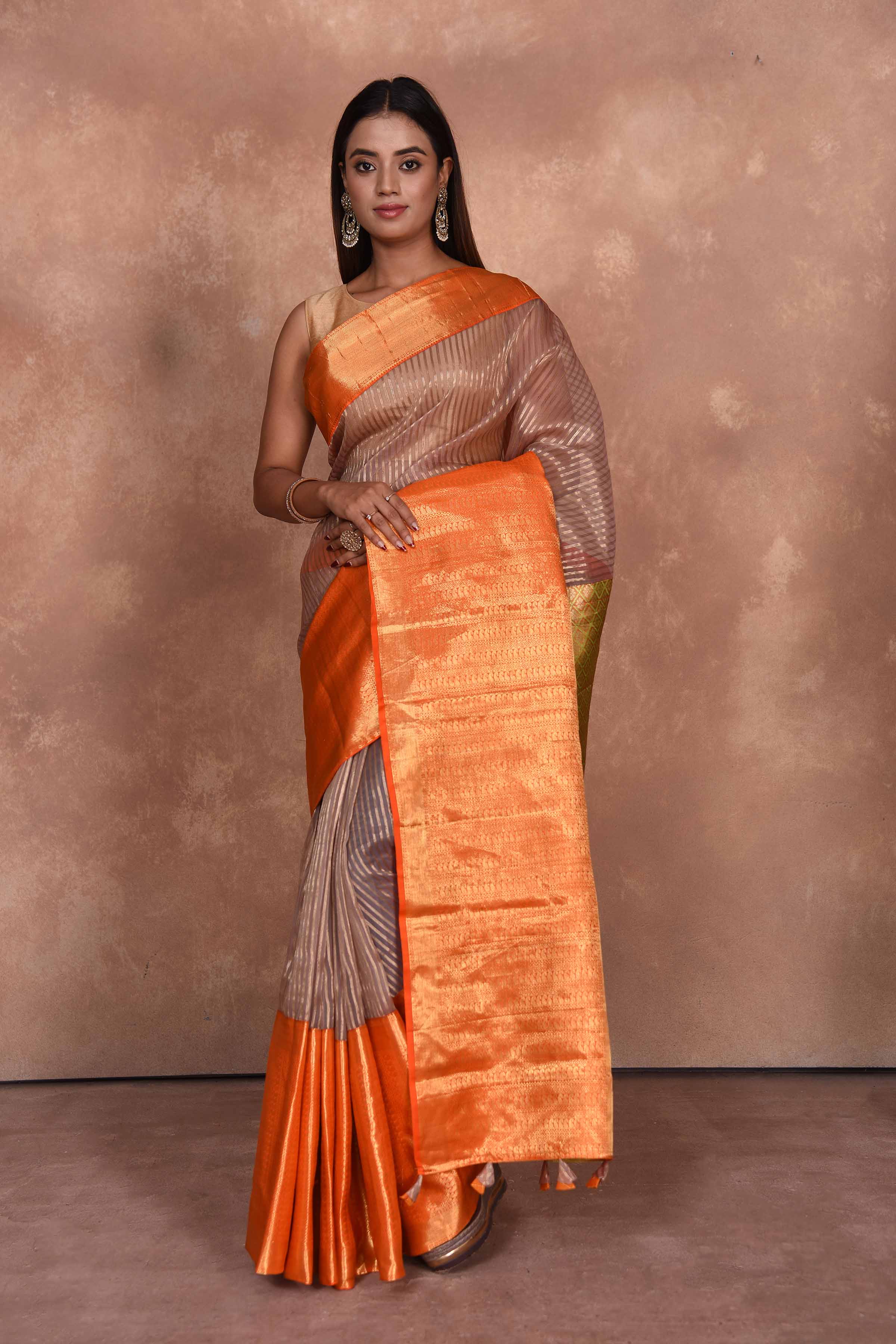 Buy beige striped Kanjeevaram Kora sari online in USA with orange zari border. Keep your ethnic wardrobe up to date with latest designer sarees, pure silk saris, Kanchipuram silk sarees, handwoven sarees, tussar silk saris, embroidered sarees, soft silk sarees, Kora silk sarees from Pure Elegance Indian saree store in USA.-full view