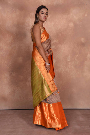 Buy beige striped Kanjeevaram Kora sari online in USA with orange zari border. Keep your ethnic wardrobe up to date with latest designer sarees, pure silk saris, Kanchipuram silk sarees, handwoven sarees, tussar silk saris, embroidered sarees, soft silk sarees, Kora silk sarees from Pure Elegance Indian saree store in USA.-side
