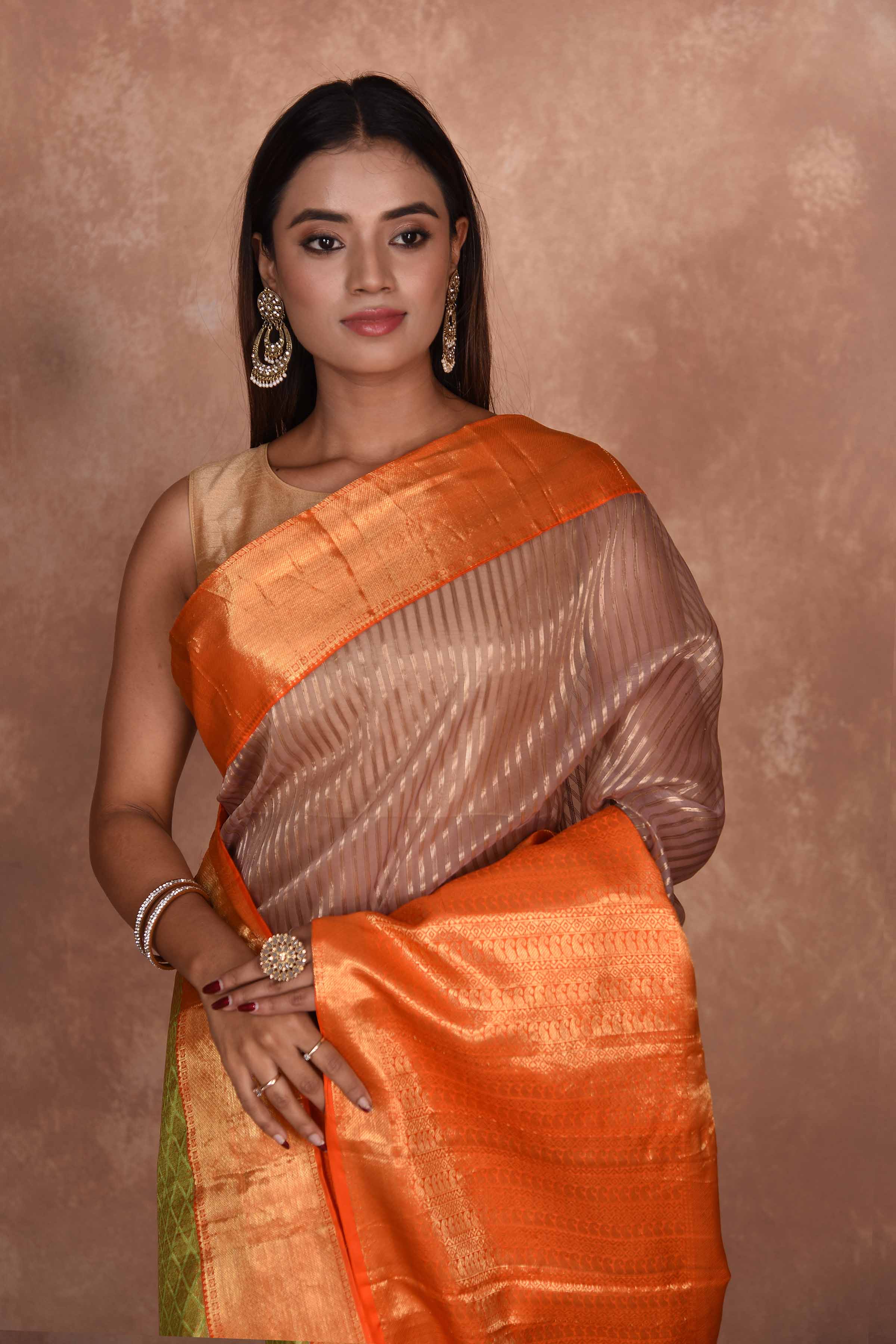 Buy beige striped Kanjeevaram Kora sari online in USA with orange zari border. Keep your ethnic wardrobe up to date with latest designer sarees, pure silk saris, Kanchipuram silk sarees, handwoven sarees, tussar silk saris, embroidered sarees, soft silk sarees, Kora silk sarees from Pure Elegance Indian saree store in USA.-closeup