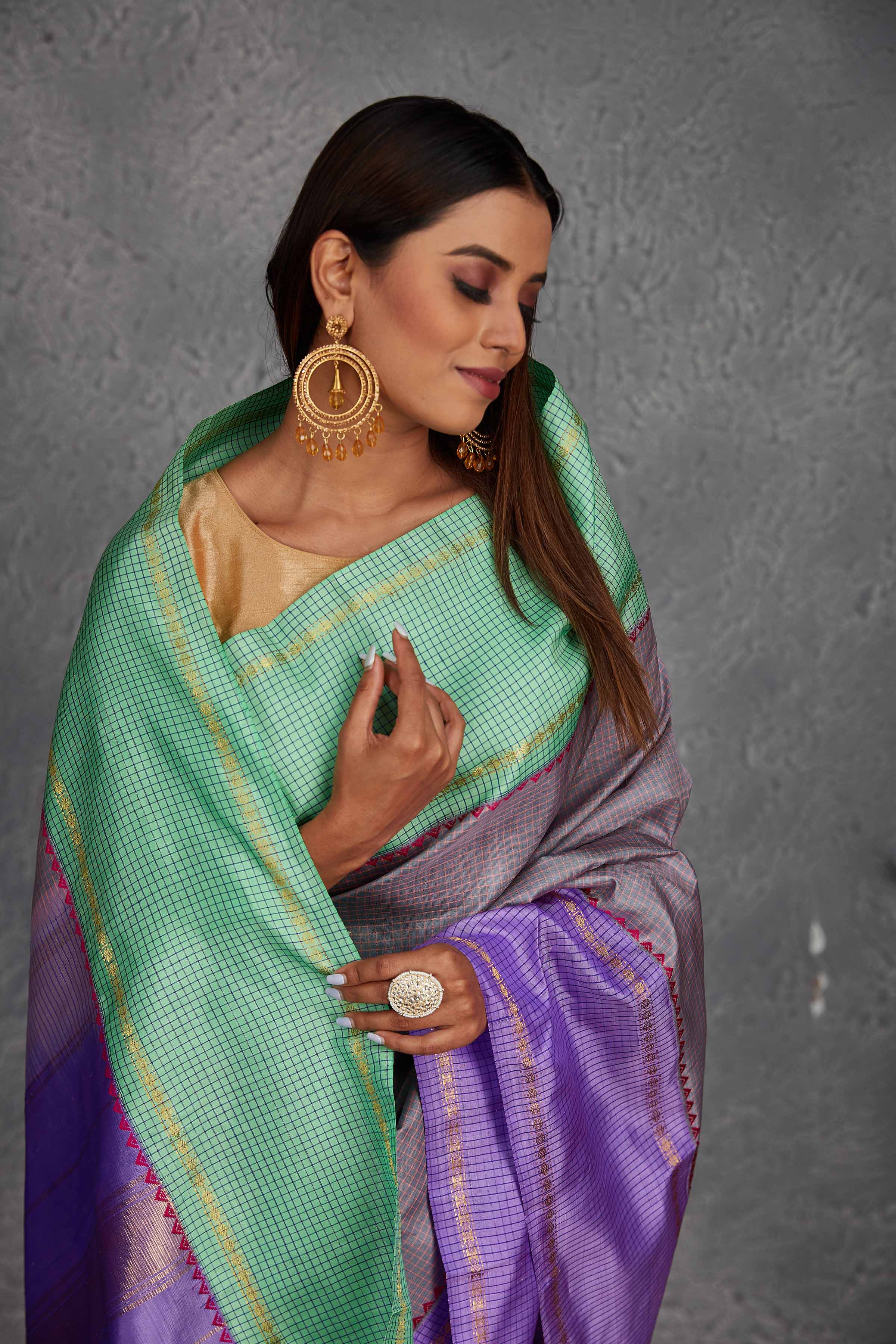 Buy beautiful grey Kanchirpuram silk sari online in USA with lavender and green border. Get festive ready in beautiful Kanchipuram silk saris, pure silk sarees, soft silk sarees, tussar silk saris, handwoven sarees, chanderi silk sarees from Pure Elegance Indian fashion store in USA.-closeup