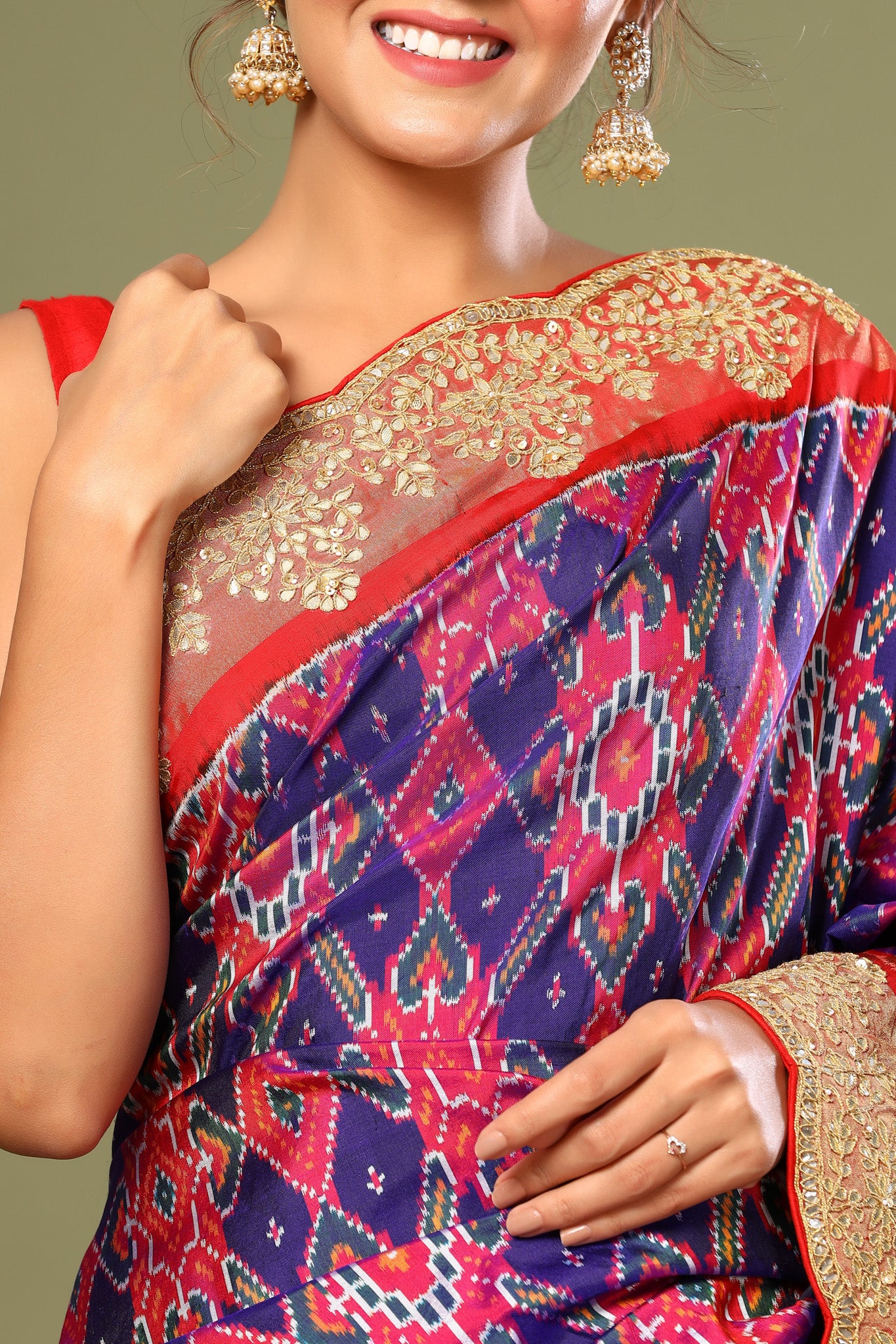 Buy purple Patola silk saree online in USA with red scalloped border. Make a fashion statement at weddings with stunning designer sarees, embroidered sarees with blouse, wedding sarees, handloom sarees from Pure Elegance Indian fashion store in USA.-closeup