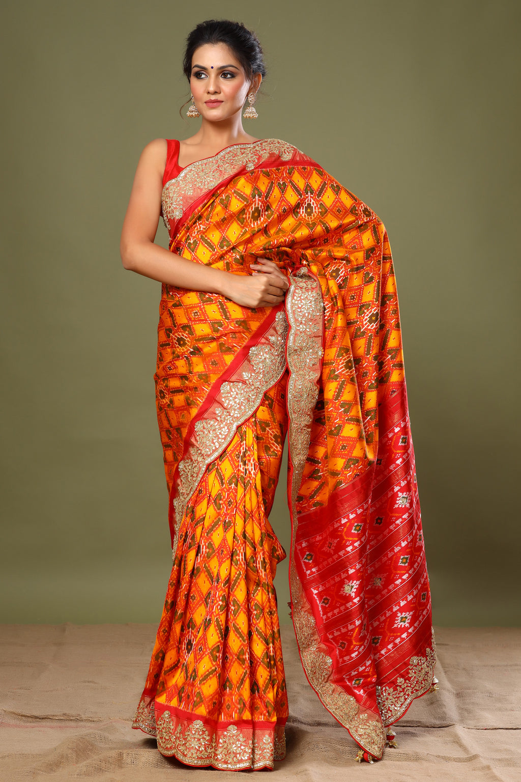 Shop orange Patola silk saree online in USA with scalloped border. Make a fashion statement at weddings with stunning designer sarees, embroidered sarees with blouse, wedding sarees, handloom sarees from Pure Elegance Indian fashion store in USA.-full view