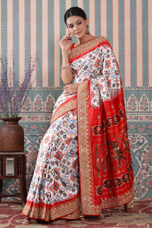 Shop white Patola silk sari online in USA with red embroidered border. Make a fashion statement at weddings with stunning designer sarees, embroidered sarees with blouse, wedding sarees, handloom sarees from Pure Elegance Indian fashion store in USA.-pallu