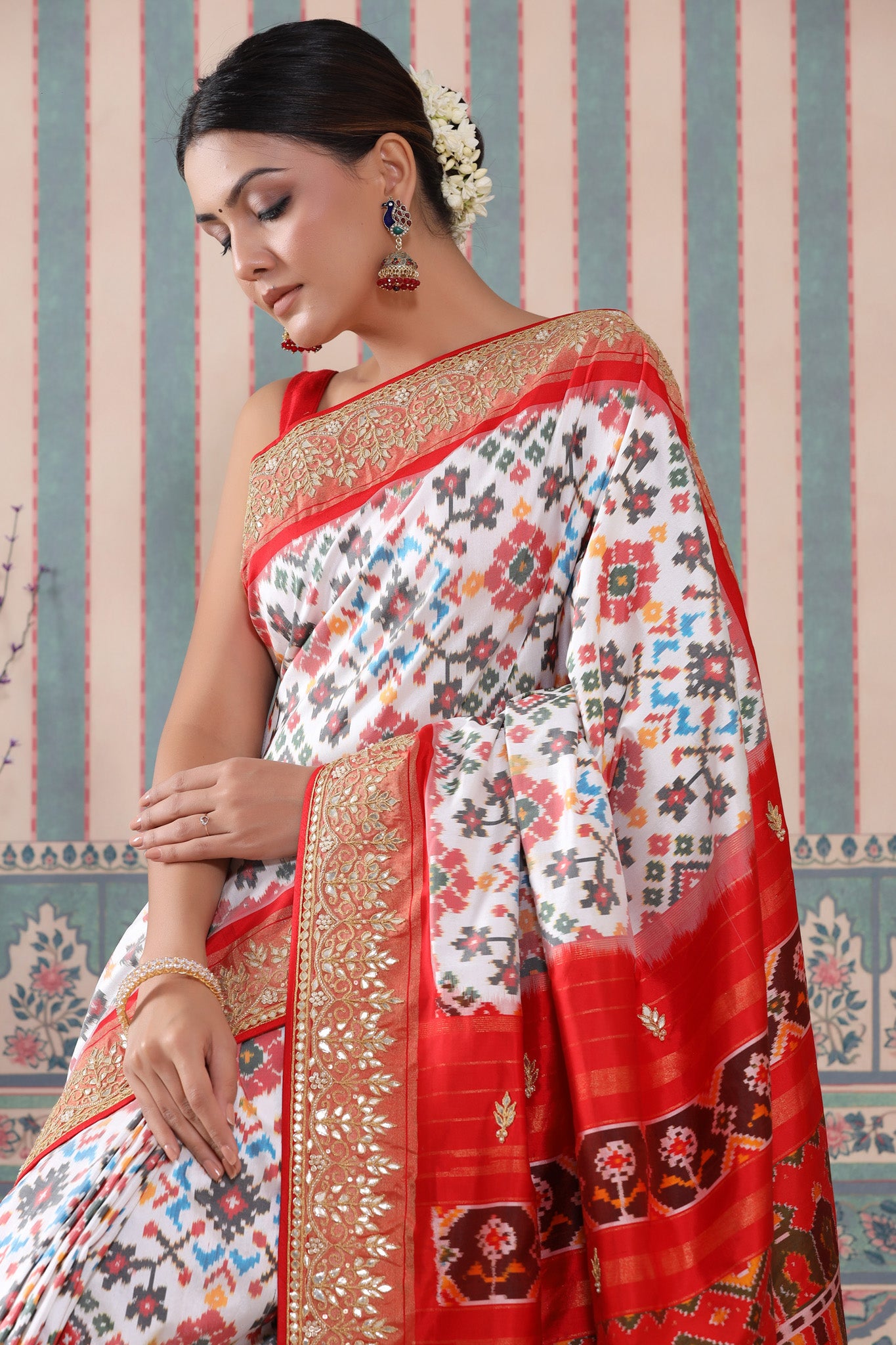 Shop white Patola silk sari online in USA with red embroidered border. Make a fashion statement at weddings with stunning designer sarees, embroidered sarees with blouse, wedding sarees, handloom sarees from Pure Elegance Indian fashion store in USA.-saree
