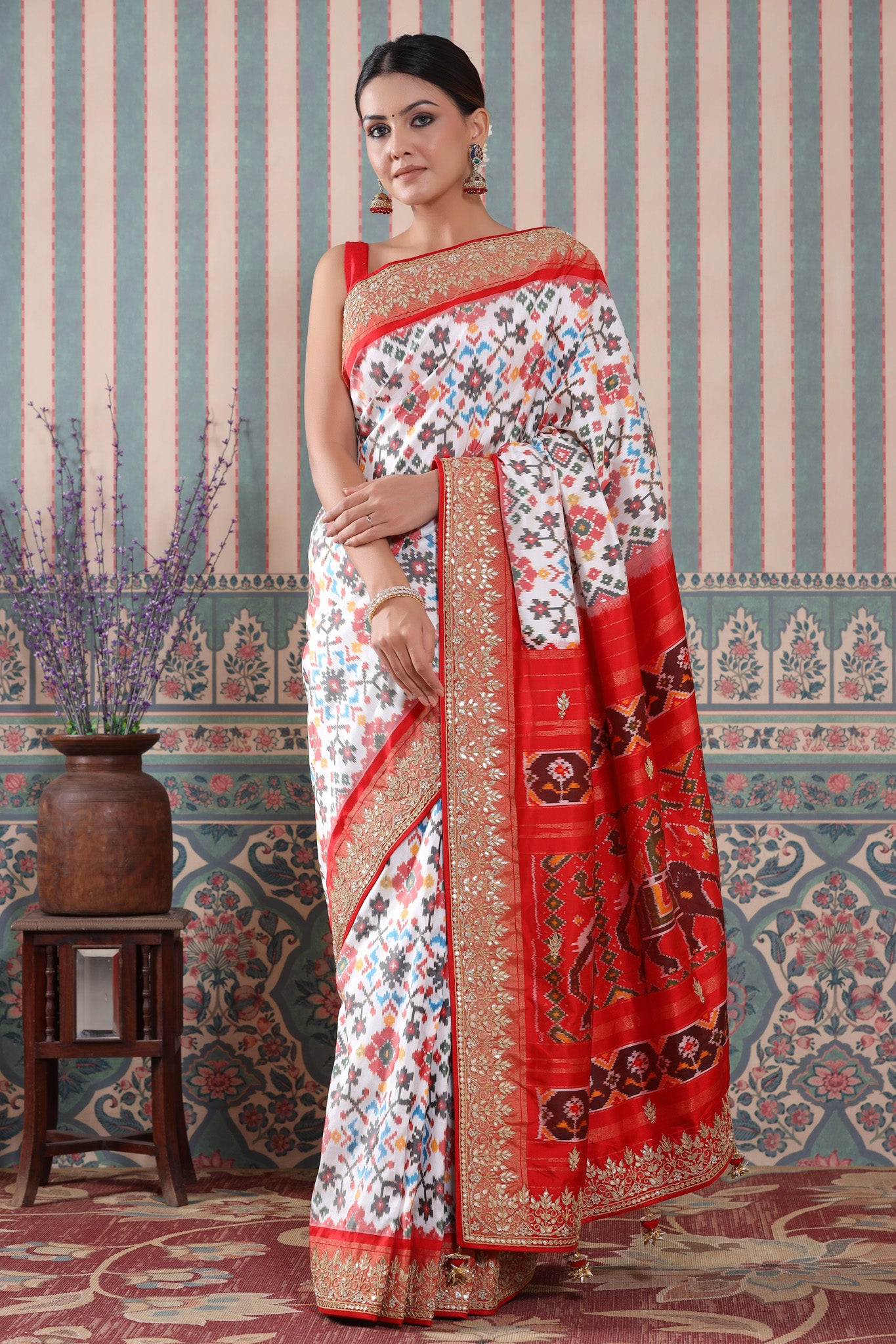 Shop white Patola silk sari online in USA with red embroidered border. Make a fashion statement at weddings with stunning designer sarees, embroidered sarees with blouse, wedding sarees, handloom sarees from Pure Elegance Indian fashion store in USA.-front