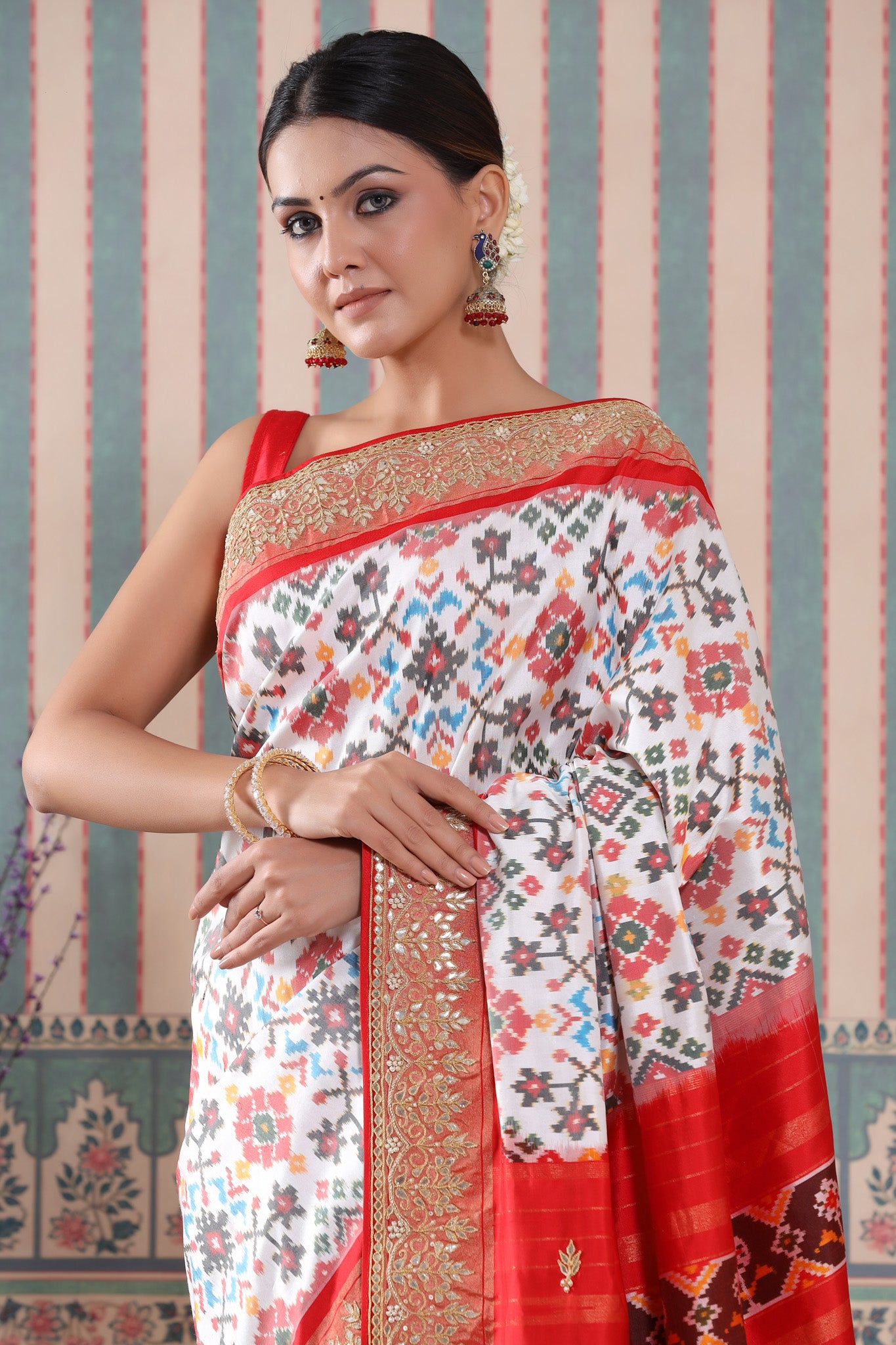 Shop white Patola silk sari online in USA with red embroidered border. Make a fashion statement at weddings with stunning designer sarees, embroidered sarees with blouse, wedding sarees, handloom sarees from Pure Elegance Indian fashion store in USA.-closeup