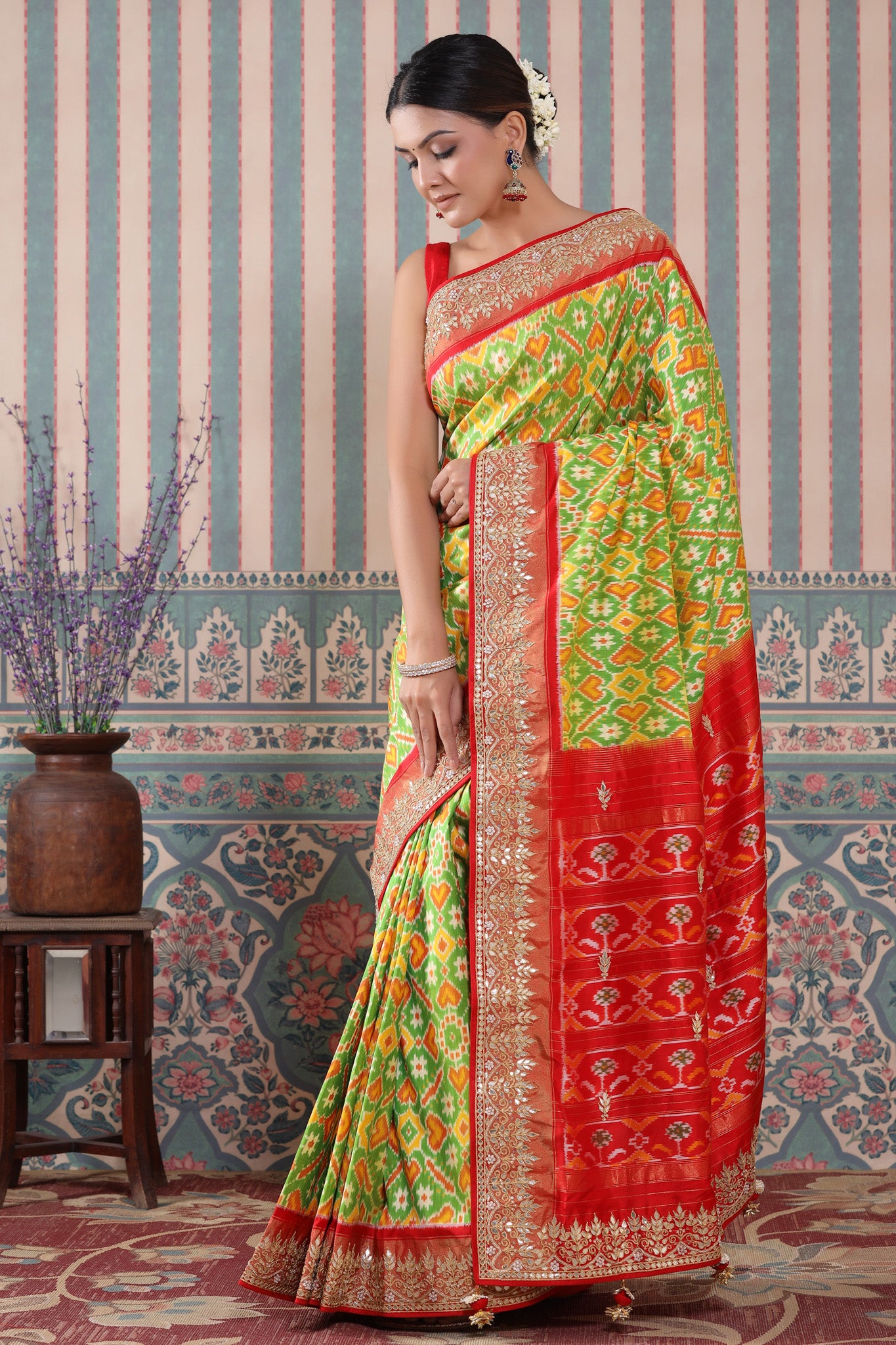 Buy green Patola silk sari online in USA with red embroidered border. Make a fashion statement at weddings with stunning designer sarees, embroidered sarees with blouse, wedding sarees, handloom sarees from Pure Elegance Indian fashion store in USA.-pallu