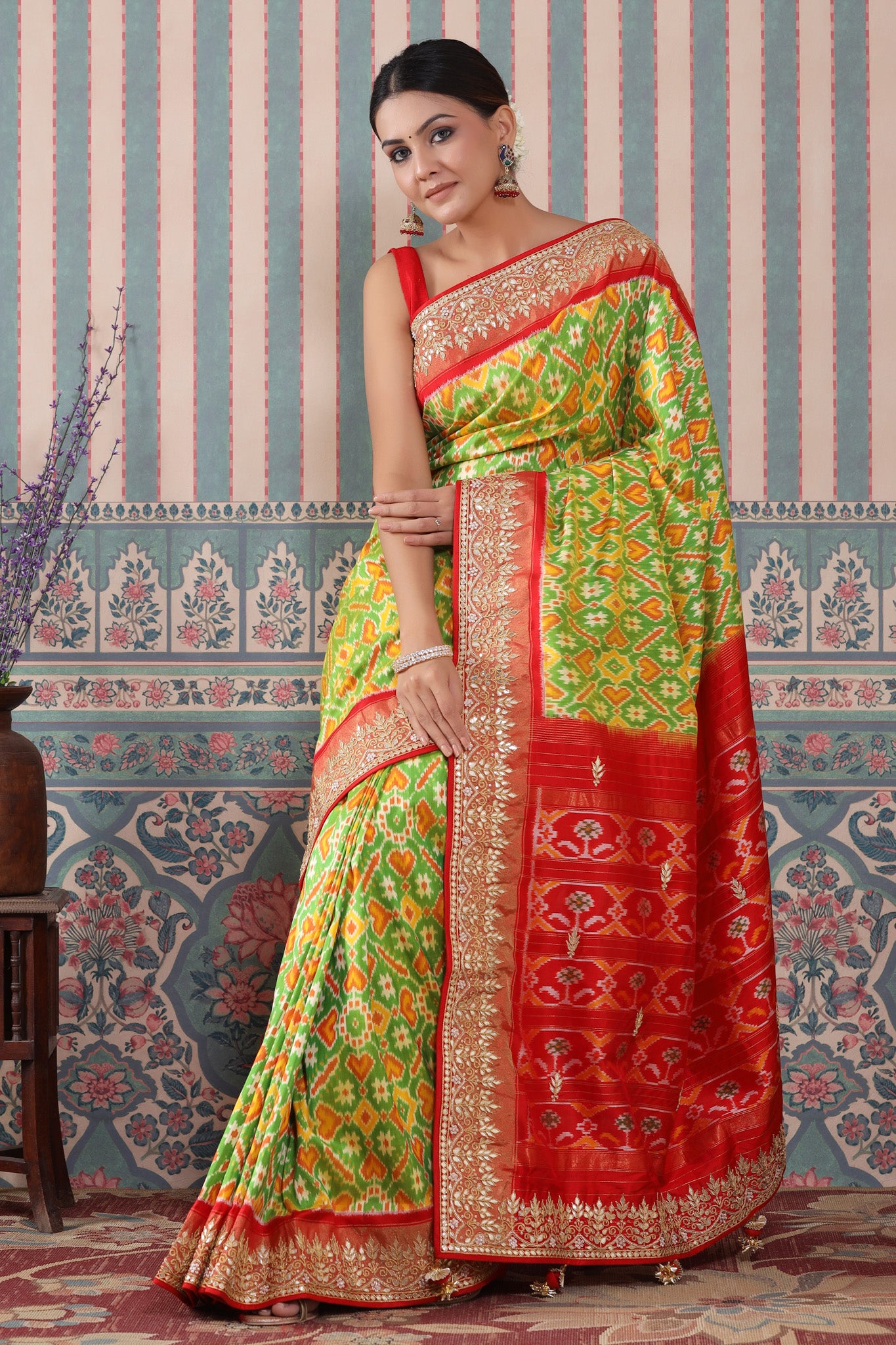 Buy green Patola silk sari online in USA with red embroidered border. Make a fashion statement at weddings with stunning designer sarees, embroidered sarees with blouse, wedding sarees, handloom sarees from Pure Elegance Indian fashion store in USA.-saree