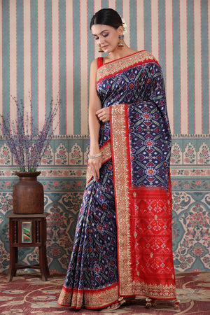 Shop blue Patola silk sari online in USA with red embroidered border. Make a fashion statement at weddings with stunning designer sarees, embroidered sarees with blouse, wedding sarees, handloom sarees from Pure Elegance Indian fashion store in USA.-front