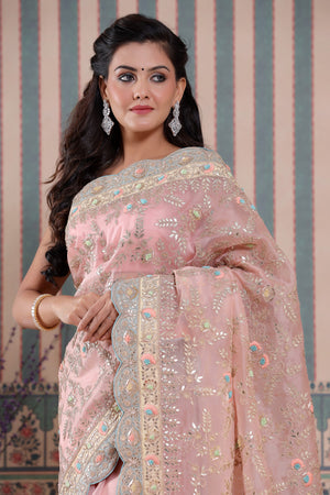 Shop light pink embroidered organza sari online in USA with scalloped border. Make a fashion statement at weddings with stunning designer sarees, embroidered sarees with blouse, wedding sarees, handloom sarees from Pure Elegance Indian fashion store in USA.-closeup