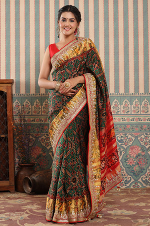 Buy dark green Patola silk sari online in USA with embroidered zari border. Make a fashion statement at weddings with stunning designer sarees, embroidered sarees with blouse, wedding sarees, handloom sarees from Pure Elegance Indian fashion store in USA.-front
