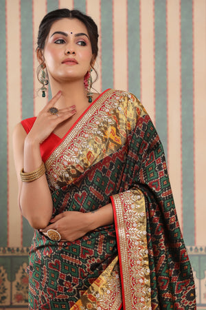 Buy dark green Patola silk sari online in USA with embroidered zari border. Make a fashion statement at weddings with stunning designer sarees, embroidered sarees with blouse, wedding sarees, handloom sarees from Pure Elegance Indian fashion store in USA.-closeup