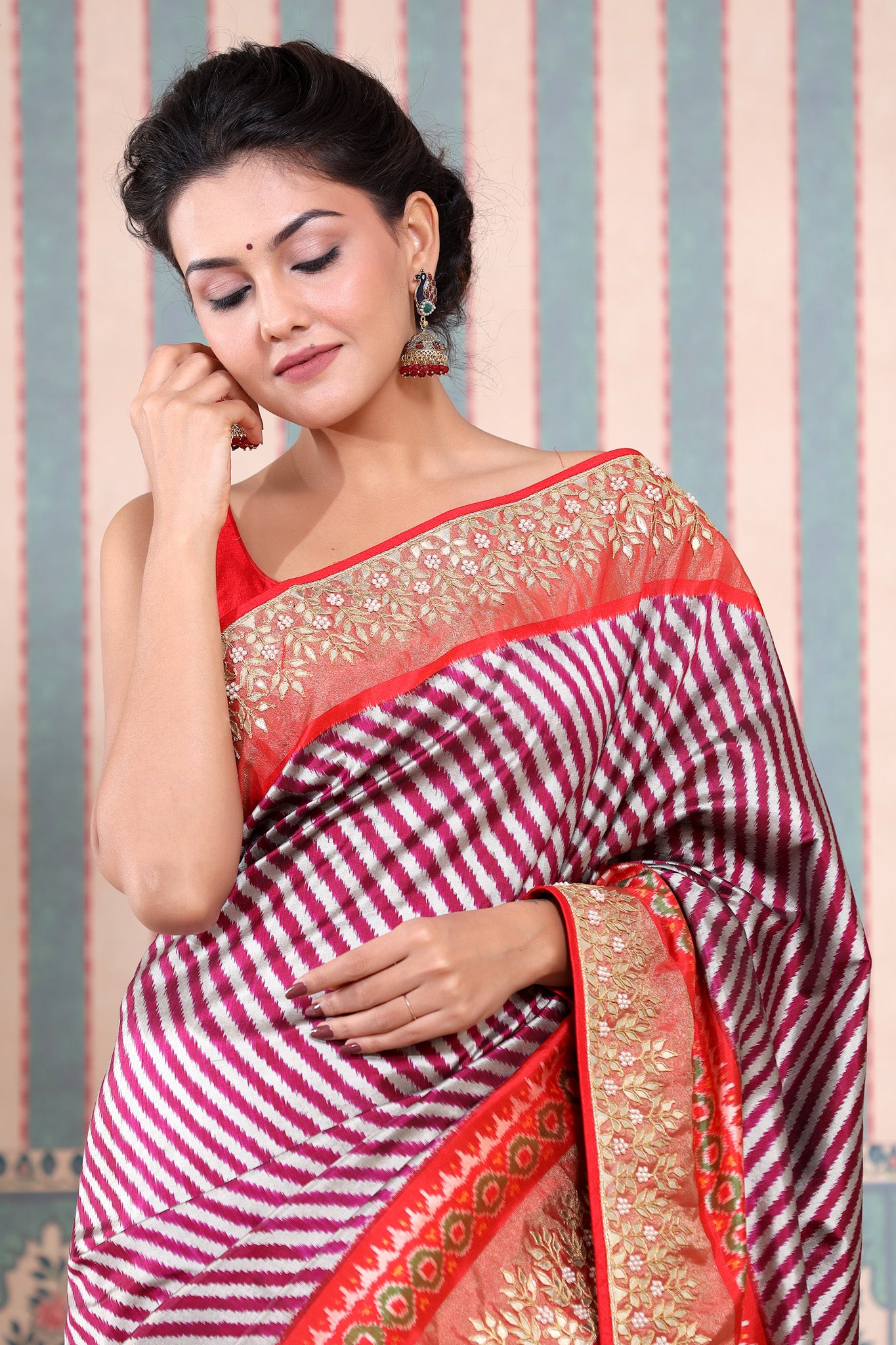 Shop maroon and silver Patola silk sari online in USA with embroidered border. Make a fashion statement at weddings with stunning designer sarees, embroidered sarees with blouse, wedding sarees, handloom sarees from Pure Elegance Indian fashion store in USA.-closeup