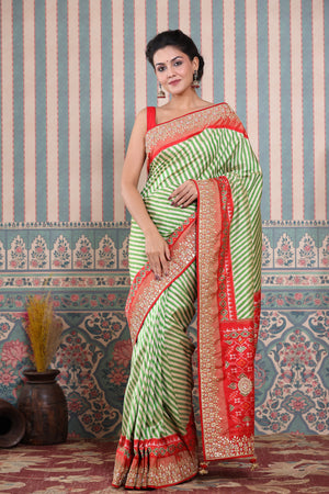 Buy green and cream Patola silk sari online in USA with embroidered border. Make a fashion statement at weddings with stunning designer sarees, embroidered sarees with blouse, wedding sarees, handloom sarees from Pure Elegance Indian fashion store in USA.-front