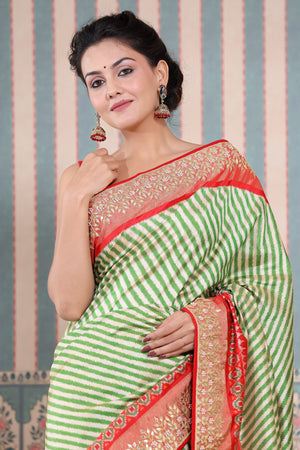 Buy green and cream Patola silk sari online in USA with embroidered border. Make a fashion statement at weddings with stunning designer sarees, embroidered sarees with blouse, wedding sarees, handloom sarees from Pure Elegance Indian fashion store in USA.-closeup