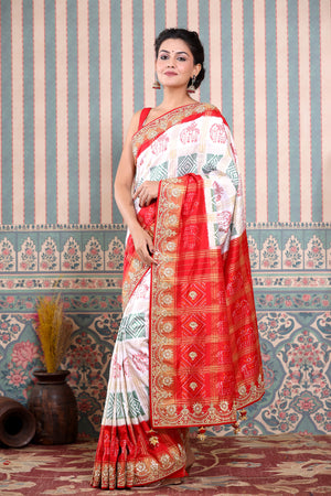 Buy beautiful white Patola silk sari online in USA with red embroidered border. Make a fashion statement at weddings with stunning designer sarees, embroidered sarees with blouse, wedding sarees, handloom sarees from Pure Elegance Indian fashion store in USA.-saree