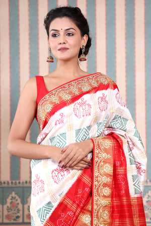 Buy beautiful white Patola silk sari online in USA with red embroidered border. Make a fashion statement at weddings with stunning designer sarees, embroidered sarees with blouse, wedding sarees, handloom sarees from Pure Elegance Indian fashion store in USA.-closeup