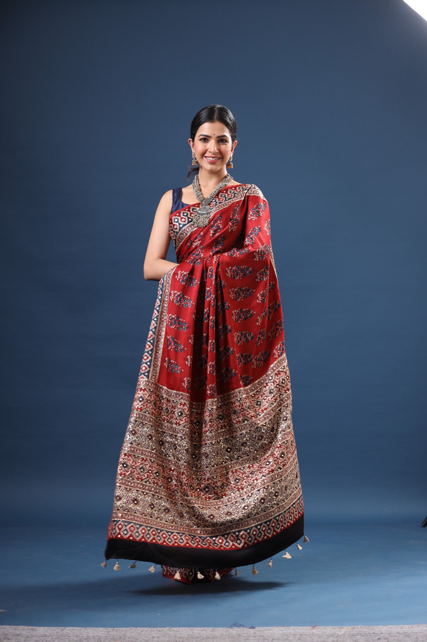 Shop stunning red Ajrakh print modal silk sari online in USA. Make a fashion statement at weddings with stunning designer sarees, embroidered sarees with blouse, wedding sarees, handloom sarees from Pure Elegance Indian fashion store in USA.-pallu