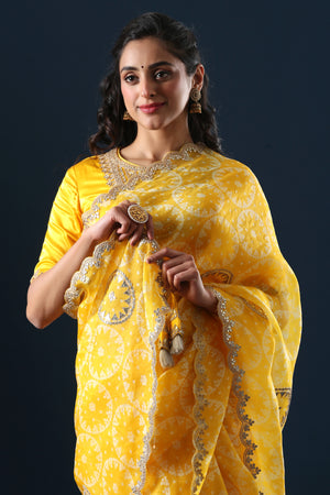 Buy yellow printed organza sari online in USA with embroidered scalloped border. Make a fashion statement at weddings with stunning designer sarees, embroidered sarees with blouse, wedding sarees, handloom sarees from Pure Elegance Indian fashion store in USA.-closeup