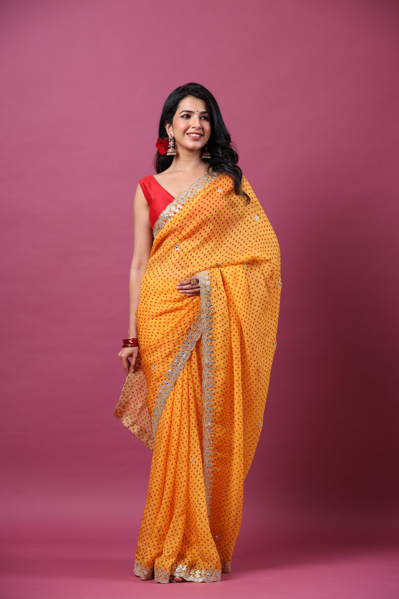 Shop orange bandhej organza sari online in USA with scalloped border. Make a fashion statement at weddings with stunning designer sarees, embroidered sarees with blouse, wedding sarees, handloom sarees from Pure Elegance Indian fashion store in USA.-front