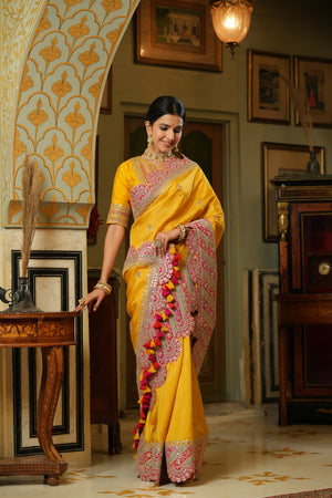 Buy yellow silk saree online in USA with heavy embroidery scalloped border. Make a fashion statement at weddings with stunning designer sarees, embroidered sarees with blouse, wedding sarees, handloom sarees from Pure Elegance Indian fashion store in USA.-front