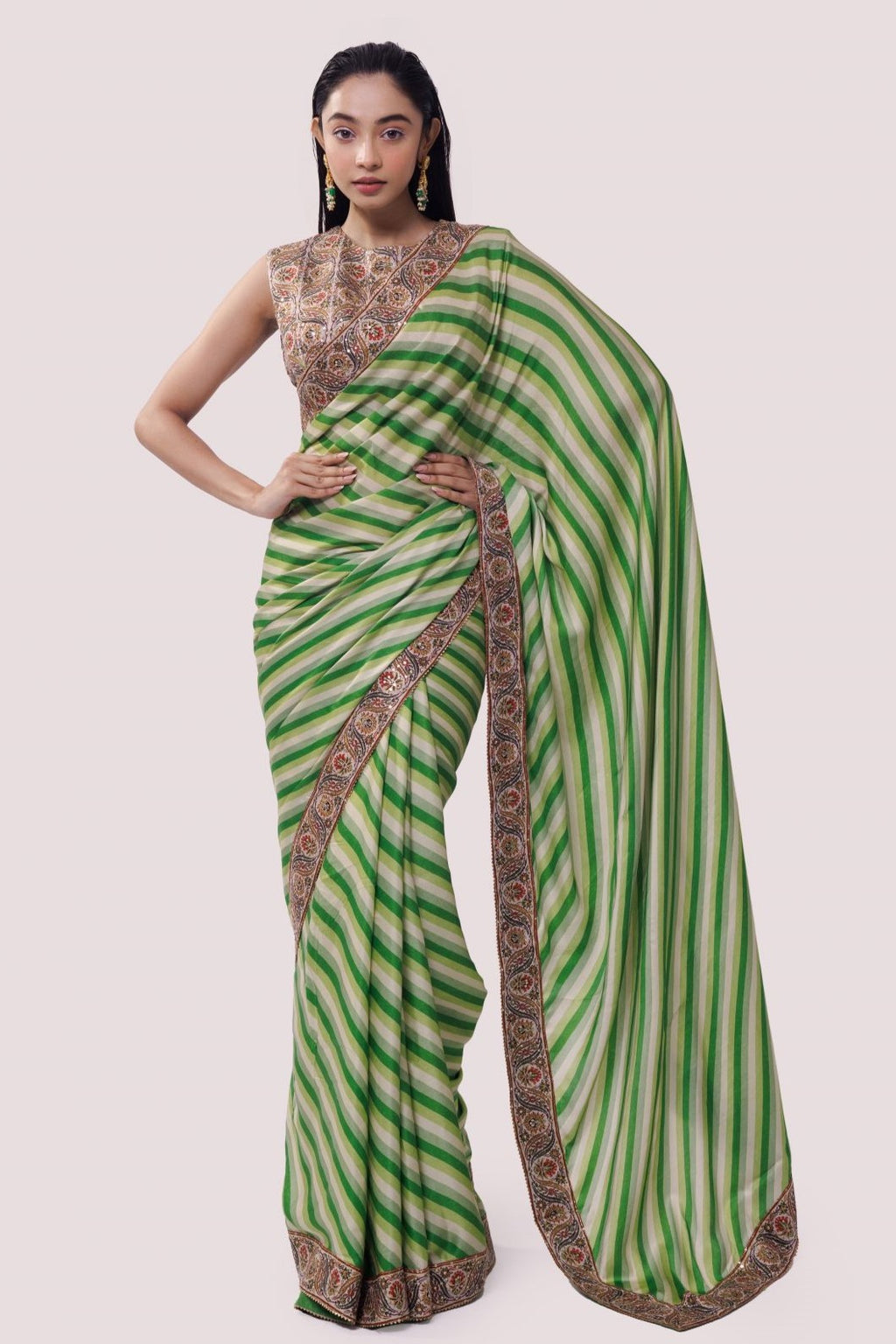 Shop an alluring green satin Saree featuring stripe print and aari work is a perfect choice for parties! It comes with a designer sleeveless saree blouse. Make a fashion statement at weddings with stunning designer sarees, embroidered sarees with blouses, wedding sarees, and handloom sarees from Pure Elegance Indian fashion store in the USA.