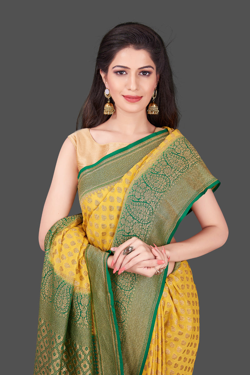 Shop lovely yellow georgette Banarasi saree online in USA with green zari border. Shop beautiful Banarasi georgette sarees, tussar sarees, pure muga silk sarees in USA from Pure Elegance Indian fashion boutique in USA. Get spoiled for choices with a splendid variety of Indian saris to choose from! Shop now.-closeup