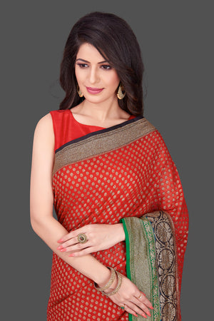 Shop stunning red georgette Benarasi saree in USA with black green zari border. Shop beautiful Banarasi georgette sarees, tussar saris, pure muga silk saris in USA from Pure Elegance Indian fashion boutique in USA. Get spoiled for choices with a splendid variety of Indian sarees to choose from! Shop now.-closeup