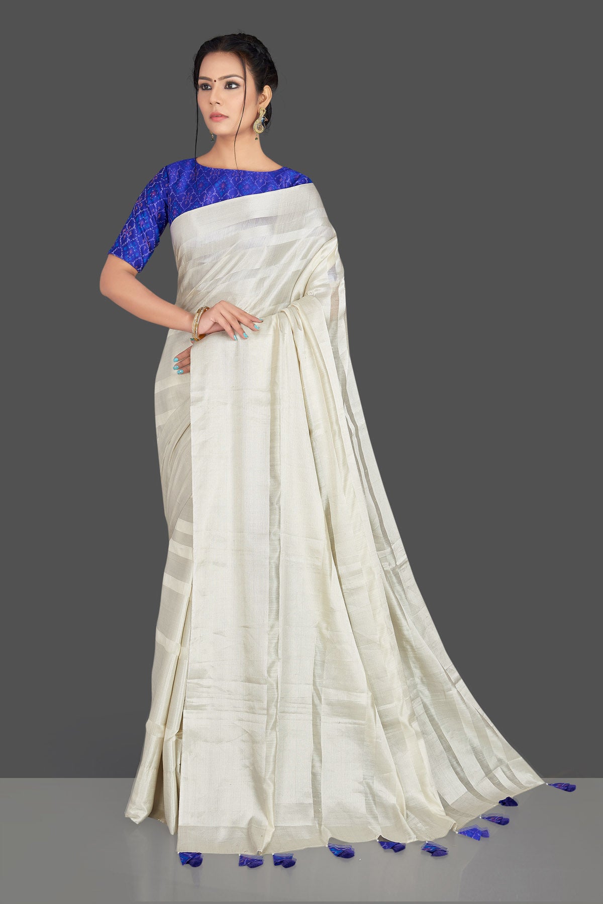 Buy lovely off-white tassar silk sari online in USA with blue patola ikkat saree blouse. Make your ethnic wardrobe rich with timeless handwoven sarees, tissue sarees, silk sarees, tussar saris from Pure Elegance Indian clothing store in USA. Find all the designer sarees for special occasions under one roof!-full view