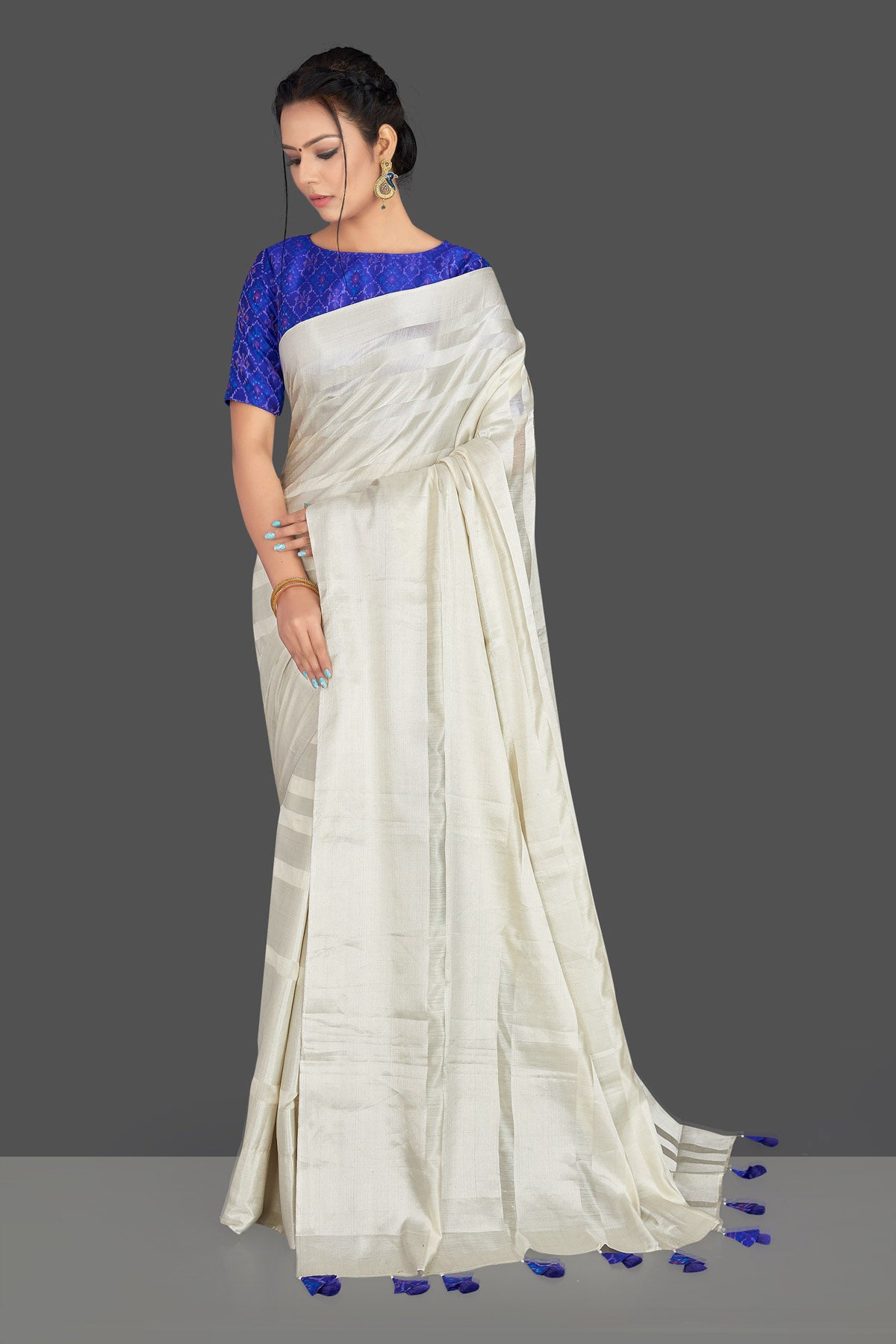 Buy lovely off-white tassar silk sari online in USA with blue patola ikkat saree blouse. Make your ethnic wardrobe rich with timeless handwoven sarees, tissue sarees, silk sarees, tussar saris from Pure Elegance Indian clothing store in USA. Find all the designer sarees for special occasions under one roof!-front