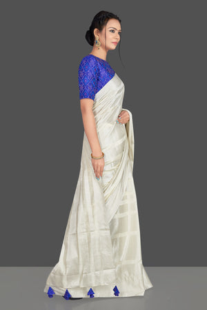 Buy lovely off-white tassar silk sari online in USA with blue patola ikkat saree blouse. Make your ethnic wardrobe rich with timeless handwoven sarees, tissue sarees, silk sarees, tussar saris from Pure Elegance Indian clothing store in USA. Find all the designer sarees for special occasions under one roof!-side