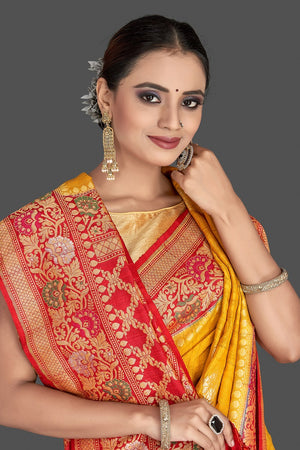 Buy stunning yellow tussar georgette Banarasi saree online in USA with red zari minakari border. Elevate your traditional style with beautiful Banarasi sarees, designer sarees, pure silk sarees, handwoven saris from Pure Elegance Indian saree store in USA.-closeup