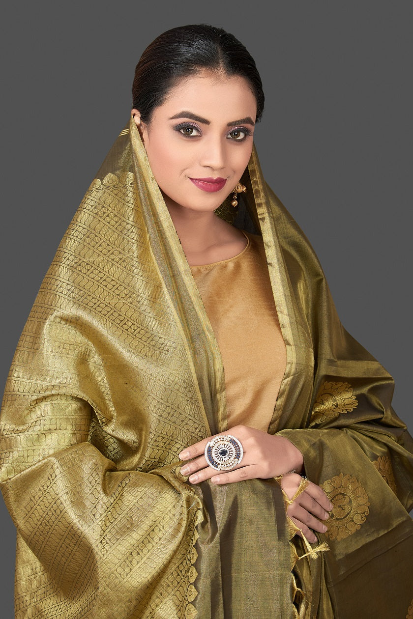 Buy gorgeous olive green handloom borderless Kanjivaram silk saree online in USA with golden zari buta. Be the center of attraction at weddings and festive occasions in the stunning handwoven silk sarees, Kanchipuram silk sarees, zari work sarees, Banarasi sarees from Pure Elegance Indian saree store in USA.-closeup