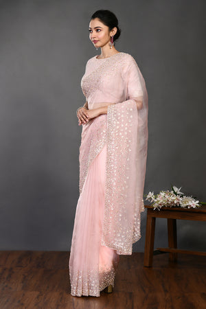 Shop powder pink embroidered organza sari online in USA with blouse. Make a fashion statement on festive occasions and weddings with designer sarees, designer suits, Indian dresses, Anarkali suits, palazzo suits, designer gowns, sharara suits, embroidered sarees from Pure Elegance Indian fashion store in USA.-pallu