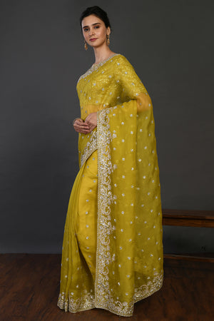 Buy mustard mirror and cutdana work organza sari online in USA with blouse. Make a fashion statement on festive occasions and weddings with designer sarees, designer suits, Indian dresses, Anarkali suits, palazzo suits, designer gowns, sharara suits, embroidered sarees from Pure Elegance Indian fashion store in USA.-pallu