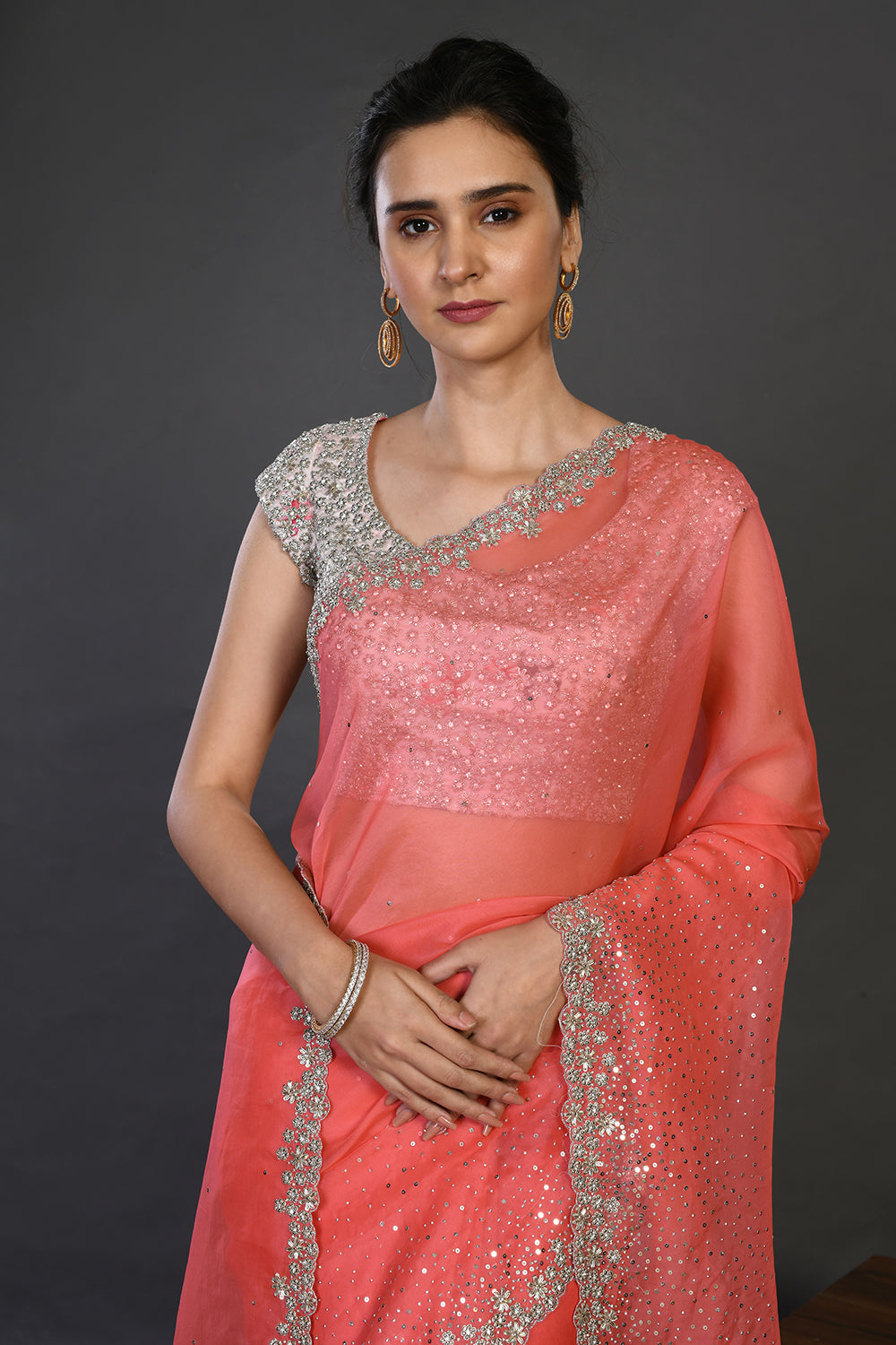 Shop coral cutdana work organza sari online in USA with blouse. Make a fashion statement on festive occasions and weddings with designer sarees, designer suits, Indian dresses, Anarkali suits, palazzo suits, designer gowns, sharara suits, embroidered sarees from Pure Elegance Indian fashion store in USA.-closeup